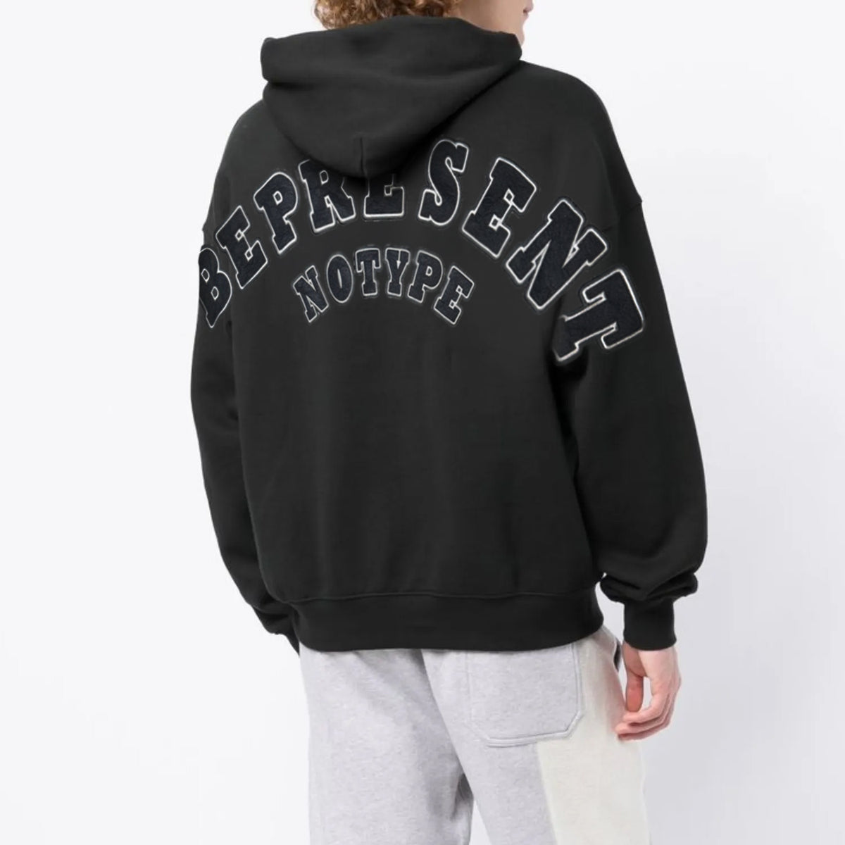 NoType BE PRESENT zip-up hoodie in black worn by a model, back view